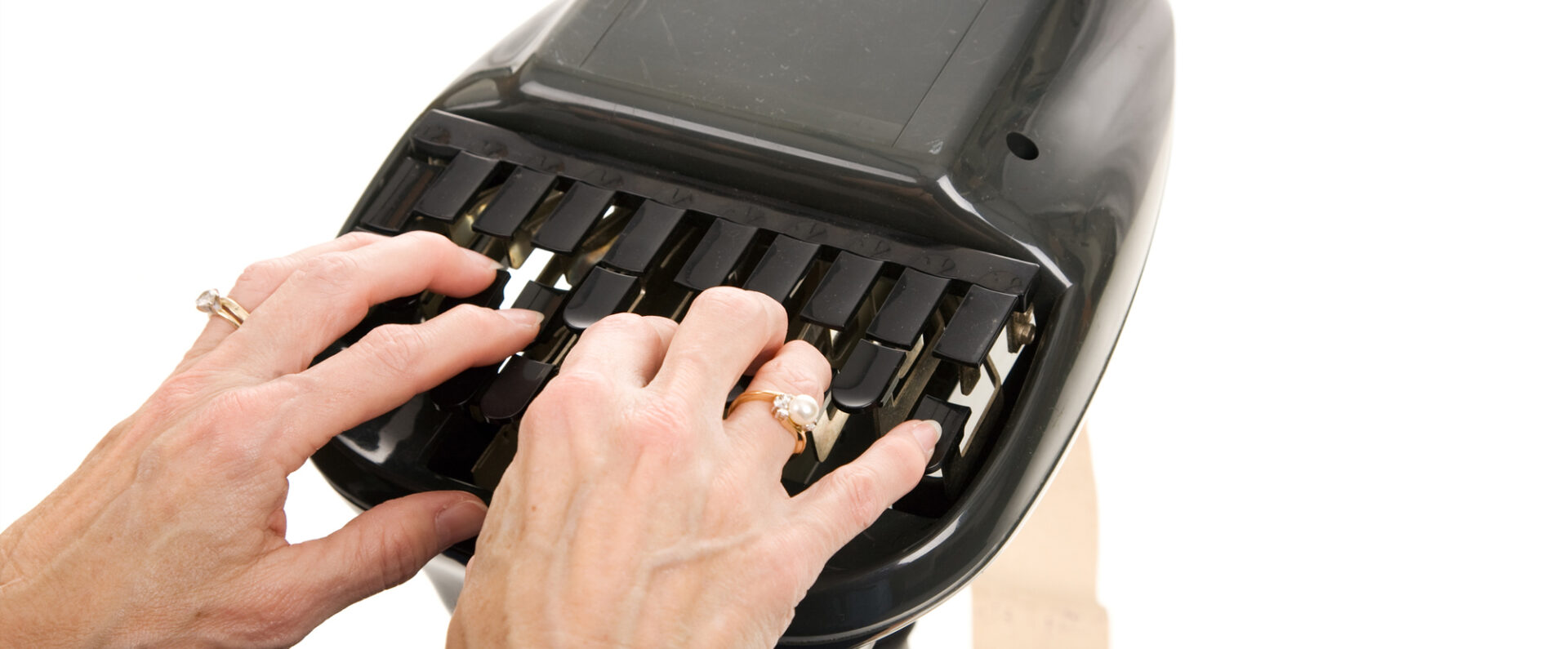 A woman types on legal equipment. EcoScribe solutions is a court reporting agency near me.